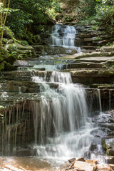 Fototapeta na wymiar Central PA Waterfall - Water Falls Down through the Green Pennsylvania Forest Over Flat Stone