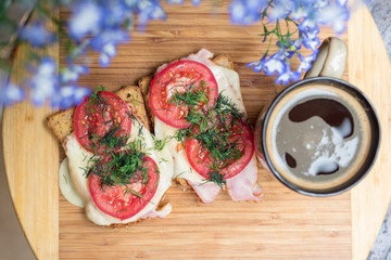 Morning breakfast sanwiches with a cup of coffee on a wooden cut