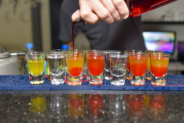 Barmen pouring colorful shots