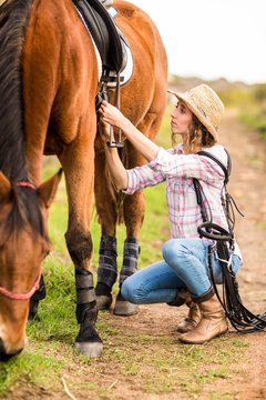Young woman walking with her horse