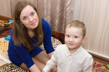 mom puts her son in fancy clothes ready for the holiday