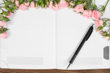 Naklejka premium Open notebook with fresh roses and pen. Empty place for your text. Romantic decor 