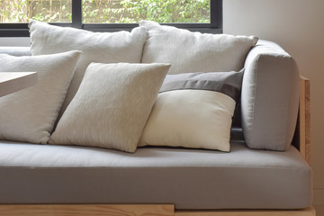 Beige varies size pillows setting on light gray comfy sofa