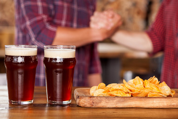 Cheerful young friends are greeting in pub