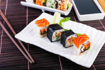 Salmon rolls  on white plate and chopsticks.  Traditional  rolls on the dish.