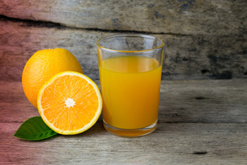 Glass of orange juice on wooden table, fresh drink