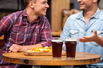 Attractive two male friends are communicating in pub