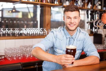 Attractive male barman is working in bar
