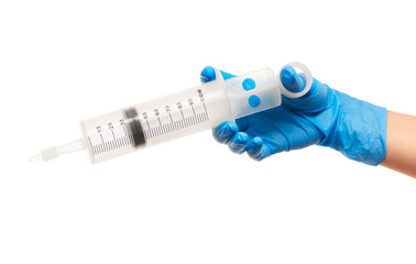Close up of female doctor's hand in blue sterilized surgical glove with large plastic medical syringe for purging ears against white background