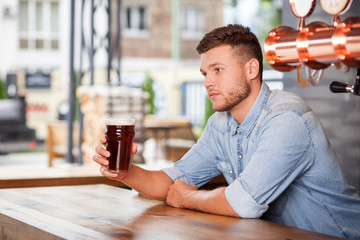 Attractive young barman is waiting for customers bar