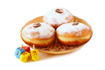 image of jewish holiday Hanukkah with donuts and wooden dreidels (spinning top). isolated on white
