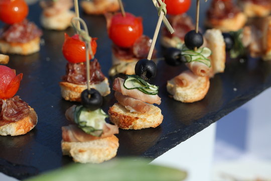 meat, fish, vegetable canapés on a festive wedding table outdoor