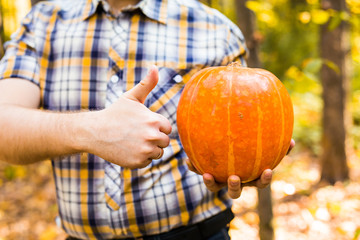 man carrying pumpkin outdoors