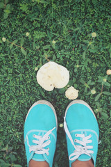 Selfie of sneakers with mushrooms on grass