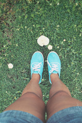 Selfie of sneakers with mushrooms on grass