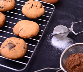 Powdered sugar in a metal strainer on black background