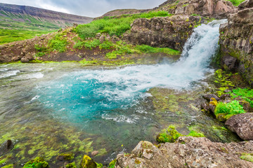 Naklejka na ściany i meble River flows from a waterfall in Iceland