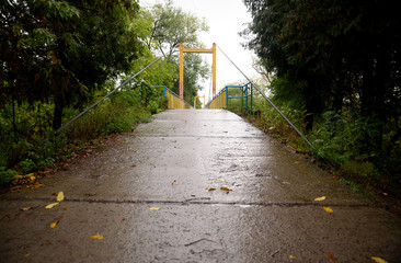 Suspension bridge across the river in the fall after the rain