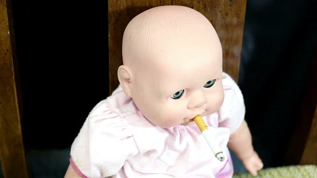 Little kids toy doll smoking a cigarette 