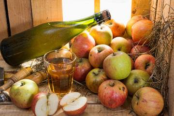bottle and glass of cider with apples