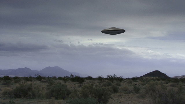 UFO 008: A flying saucer hovers over a windy desert.