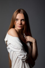 Fototapeta premium студийный портрет девушки в белой рубашке на сером фоне