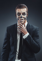 Surprised businessman with a makeup  skeleton