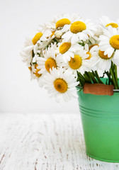 bouquet of daisies in a metal bucket
