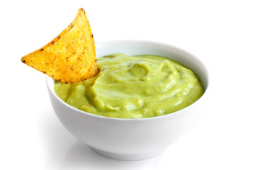 Round white bowl of guacamole dip isolated in perspective. Torti - obrazy, fototapety, plakaty