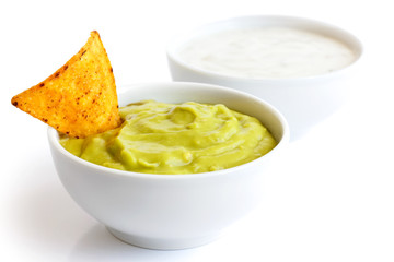 Round white bowl of guacamole dip isolated in perspective. Torti