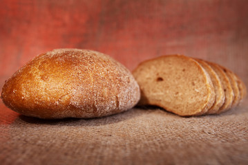 Black bread on sackcloth background. Selective focus