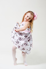 Naklejka premium Full length portrait of a cute little blonde girl dancing