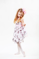 Naklejka premium Full length portrait of a cute little blonde girl dancing