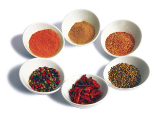 Various spices in white bowls.