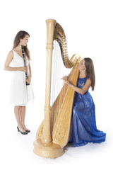 Obraz premium two young women in studio with harp and clarinet against white b