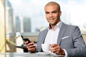 Pleasant businessman drinking coffee 