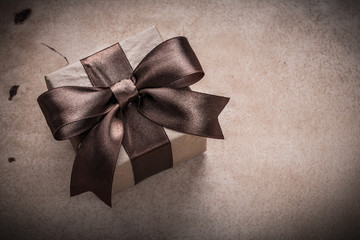 Present box with tied bow paper on vintage background