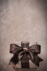 Wrapped gift box with tied ribbon paper on vintage background