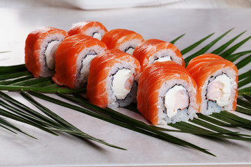 Philadelphia roll with shrimp sushi food on a tropical palm