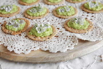 Green avocado crackers with coriander flowers