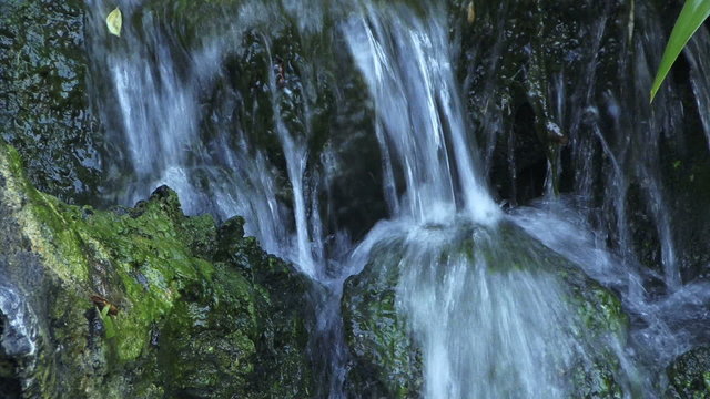 Waterfall 0502: Close up of a waterfall splashing on mossy rocks (Loop).