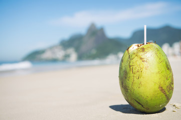 Green coconut coco gelado on Ipanema Beach against a backdrop of Two Brothers Dois Irmaos Mountain Rio de Janeiro Brazil