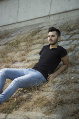 young man posing. rustic old stones.