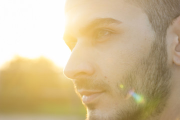 face close up of young men, strong sun light and lens flare.