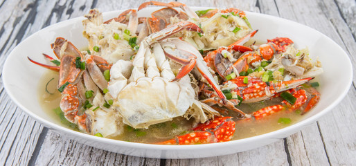 Malaysian dish clear crab soup in an oblong plate over wooden background