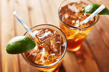 iced sweet tea with lime wedges and retro paper straw shot from angle looking down