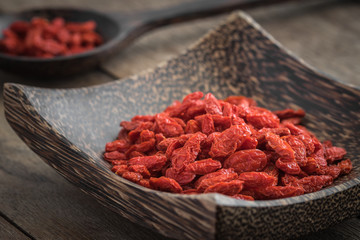 Goji berries on wooden plate and spoon