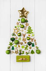 Weihnachtsbaum mit grün, gold und weiß dekoriert. Weihnachtliche Dekoration mit Holz.