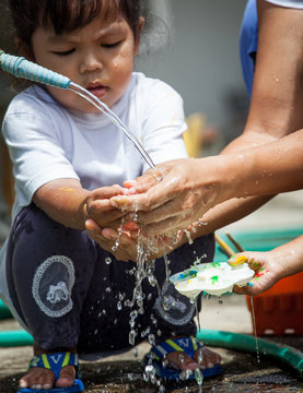 Mother And Her Child Washing Hands Together After Painted