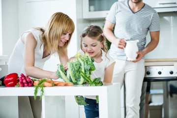 Junge Familie mit frischem Gemüse in der Küche